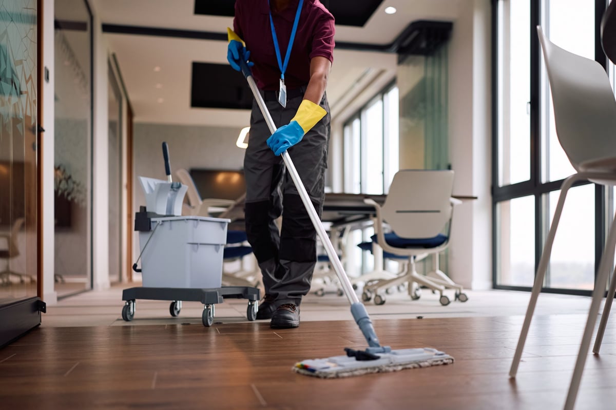 NUCleaningCo crew member mopping a polished office floor
